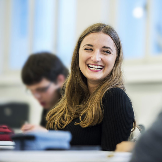 Etudiante assise en classe, souriante
